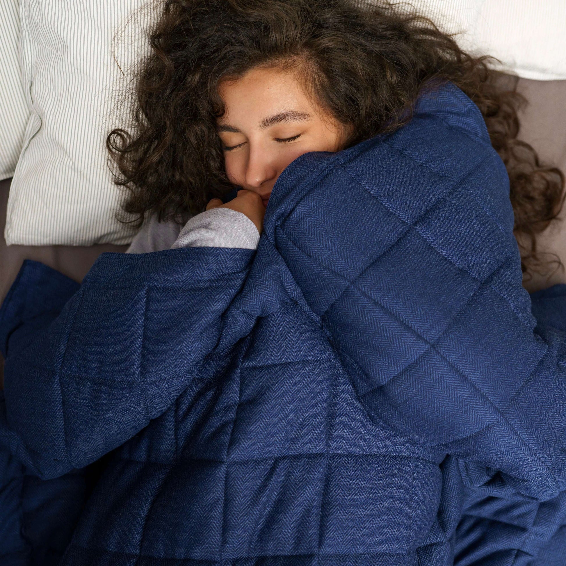 Blaue Gewichtsdecke aus Merinowolle Noe von KNUS mit Model