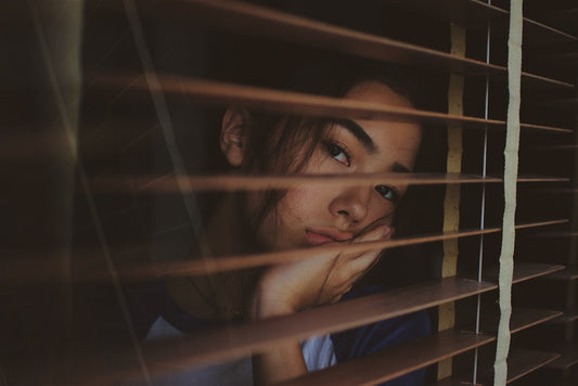 Winterdepressionen - Frau mit traurigem Gesicht am Fenster 