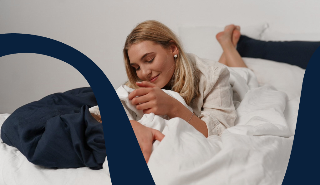 Bild: Frau im Bett mit nachhaltiger Gewichtsdecke in weiß mit Bezug aus Tencel und Leinen